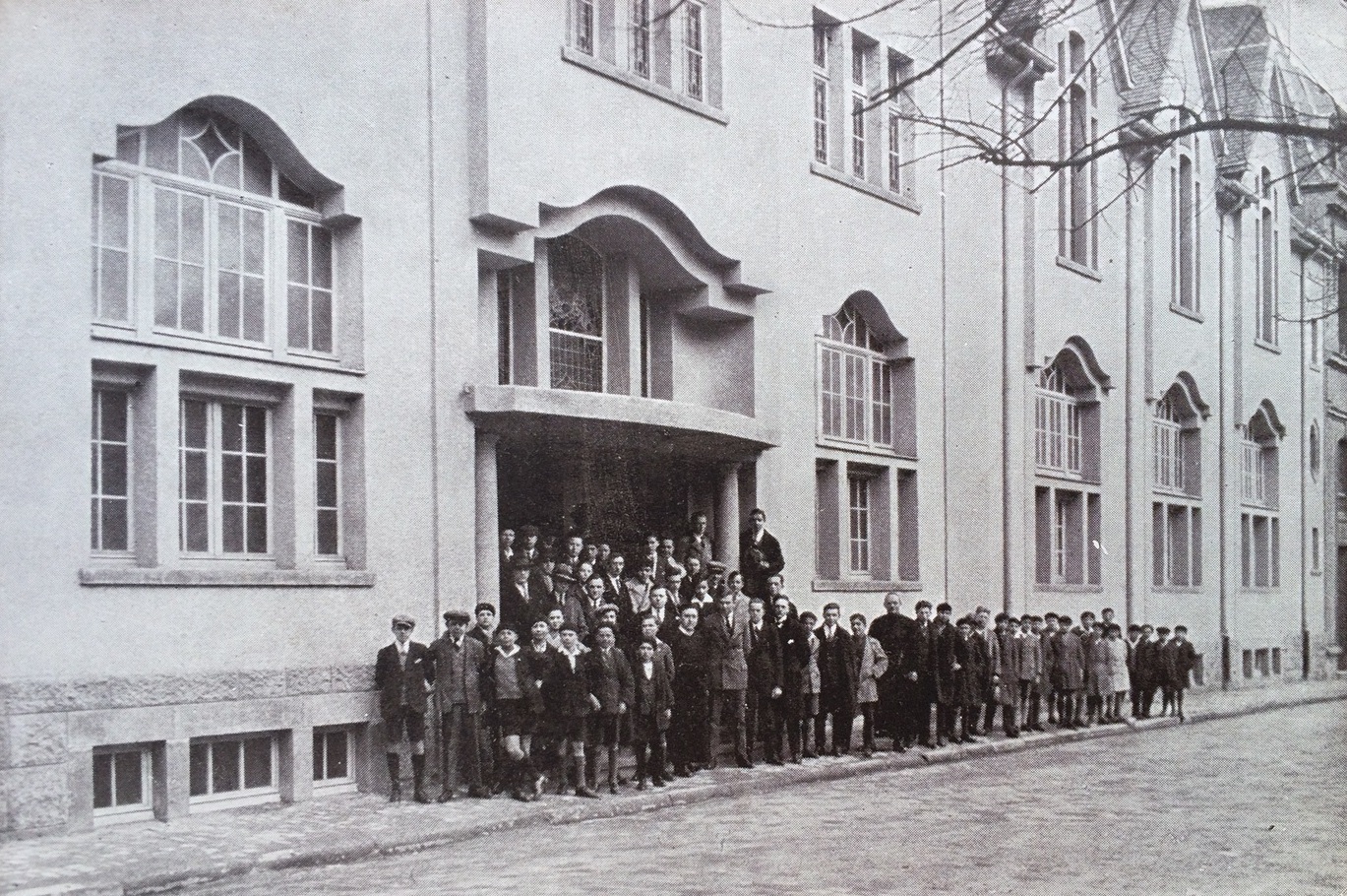 Bâtiment Vo en 1928 avec prêtres et enfants devant les escaliers